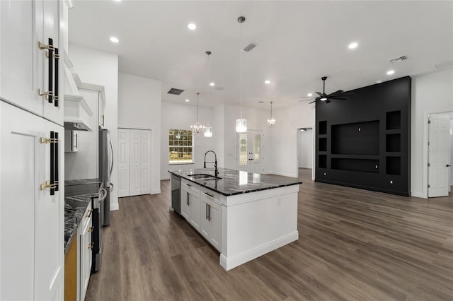 kitchen featuring stainless steel appliances, sink, decorative light fixtures, a center island with sink, and white cabinets