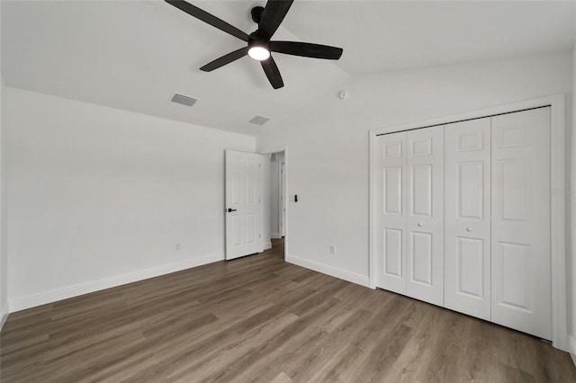 unfurnished bedroom with a closet, hardwood / wood-style flooring, ceiling fan, and lofted ceiling