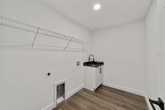 washroom with hookup for an electric dryer, washer hookup, cabinets, and dark wood-type flooring