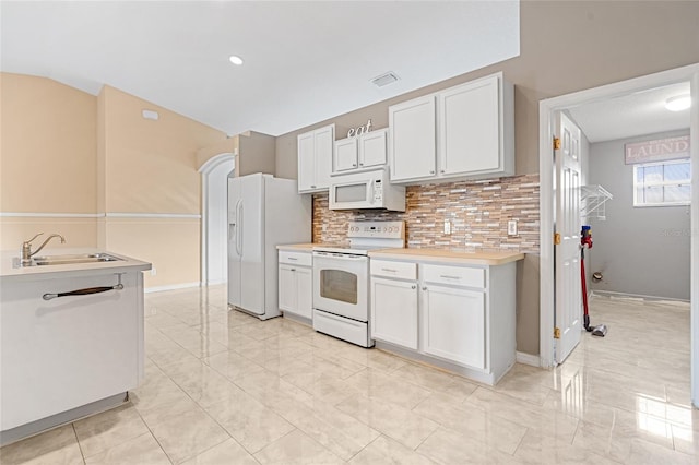 kitchen with white cabinets, white appliances, backsplash, and sink