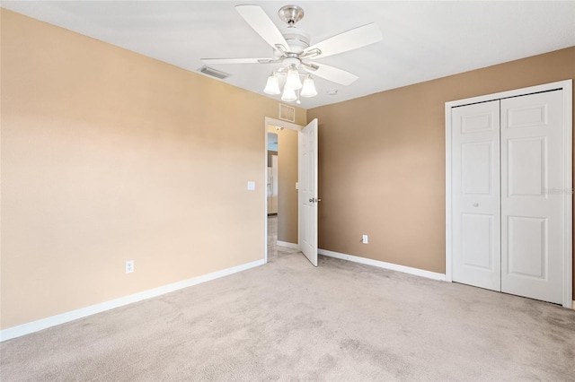 unfurnished bedroom featuring ceiling fan, light colored carpet, and a closet