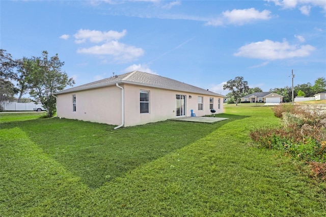 rear view of property featuring a yard and a patio