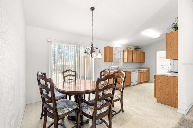 dining area featuring plenty of natural light, lofted ceiling, and an inviting chandelier