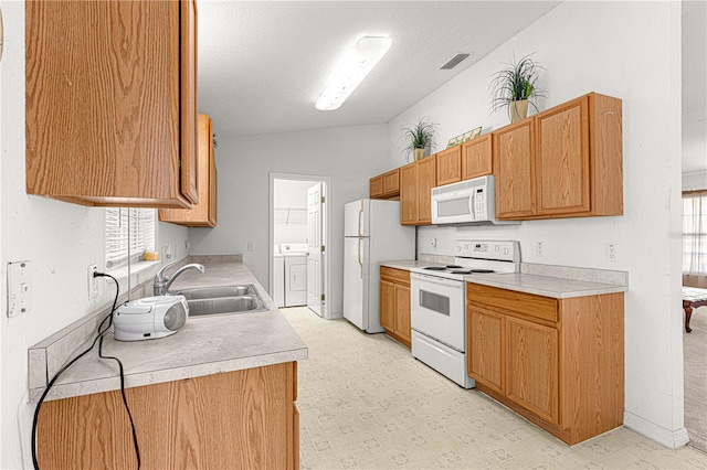 kitchen with a textured ceiling, white appliances, vaulted ceiling, and sink