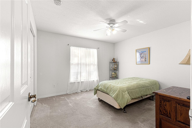 carpeted bedroom featuring ceiling fan, a textured ceiling, and a closet