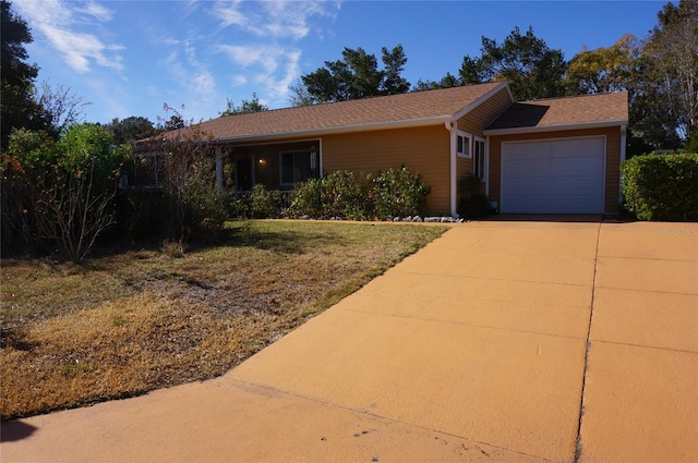 single story home with a garage, driveway, and a front yard