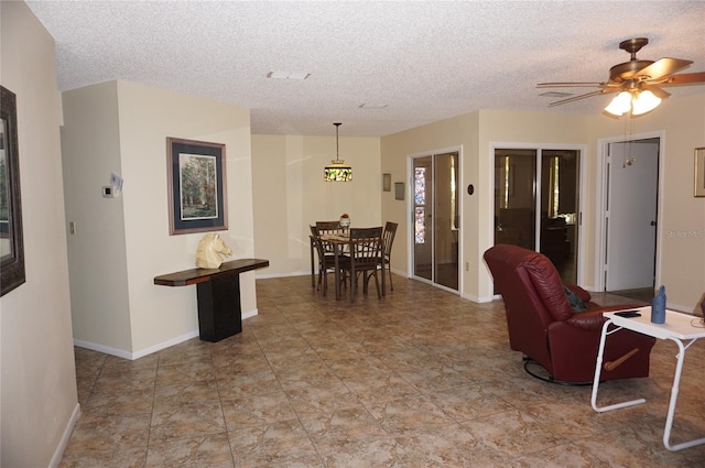 dining space with a textured ceiling and ceiling fan