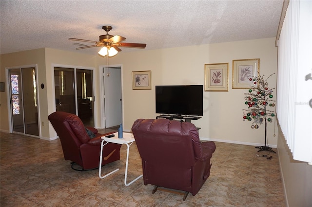 living room featuring a wealth of natural light, ceiling fan, and a textured ceiling