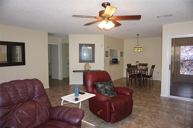 living room featuring a textured ceiling and ceiling fan