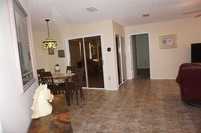 dining room with ceiling fan and a textured ceiling