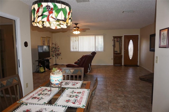 dining room with ceiling fan and a textured ceiling