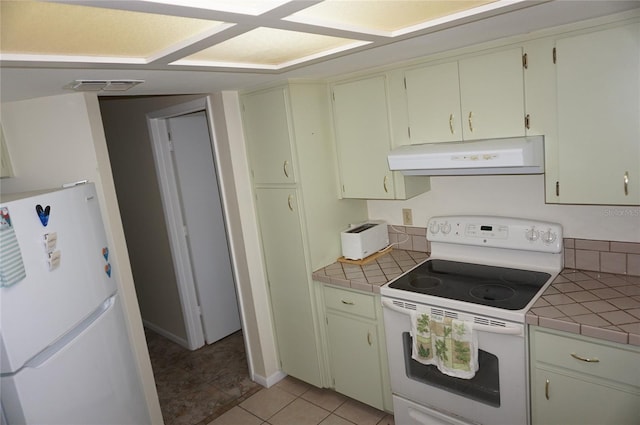 kitchen featuring white appliances, tile counters, and light tile patterned flooring