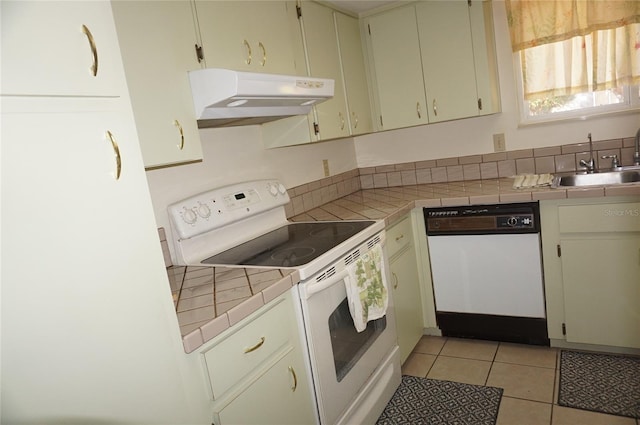 kitchen featuring light tile patterned floors, white appliances, tile counters, and sink