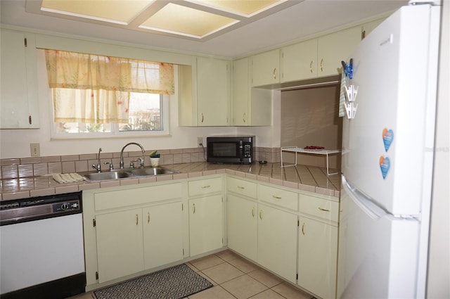 kitchen featuring light tile patterned flooring, white appliances, tile counters, and sink