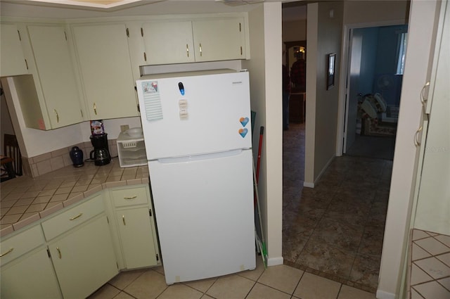 kitchen with tile countertops, white fridge, and light tile patterned flooring