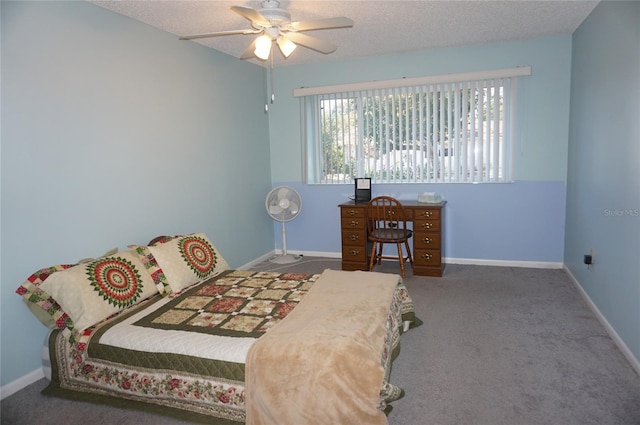 bedroom featuring dark colored carpet, ceiling fan, and a textured ceiling