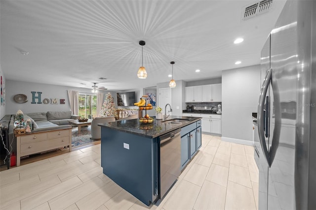 kitchen with a kitchen island with sink, blue cabinets, sink, white cabinetry, and stainless steel appliances