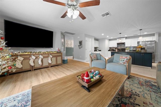 living room featuring light hardwood / wood-style floors and ceiling fan