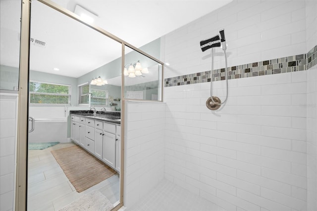 bathroom with tile patterned floors, vanity, and shower with separate bathtub