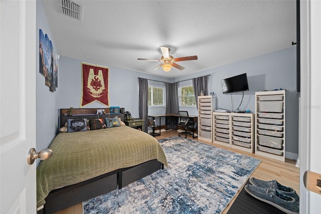 bedroom featuring ceiling fan, a textured ceiling, and hardwood / wood-style flooring