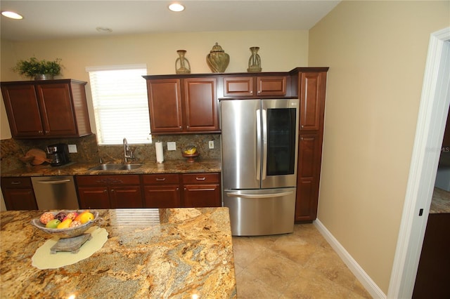 kitchen with decorative backsplash, appliances with stainless steel finishes, sink, light tile patterned floors, and stone counters