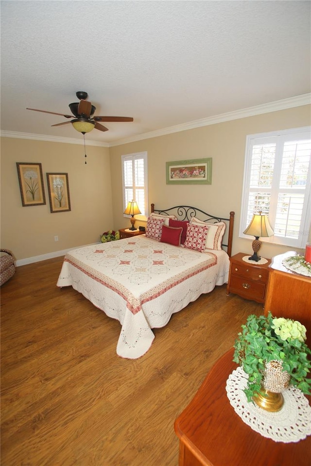 bedroom with crown molding, wood-type flooring, a textured ceiling, and ceiling fan