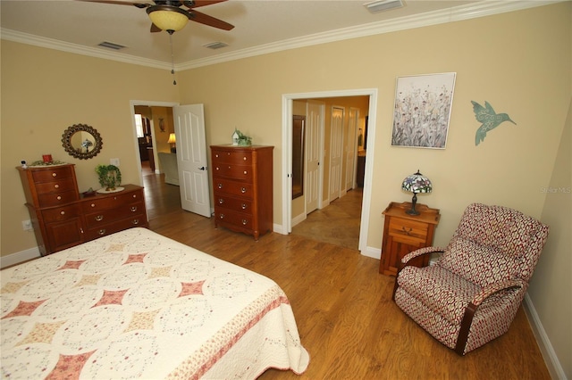 bedroom with ceiling fan, hardwood / wood-style flooring, and ornamental molding