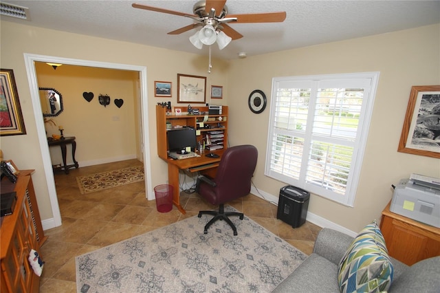 tiled home office featuring ceiling fan and a textured ceiling