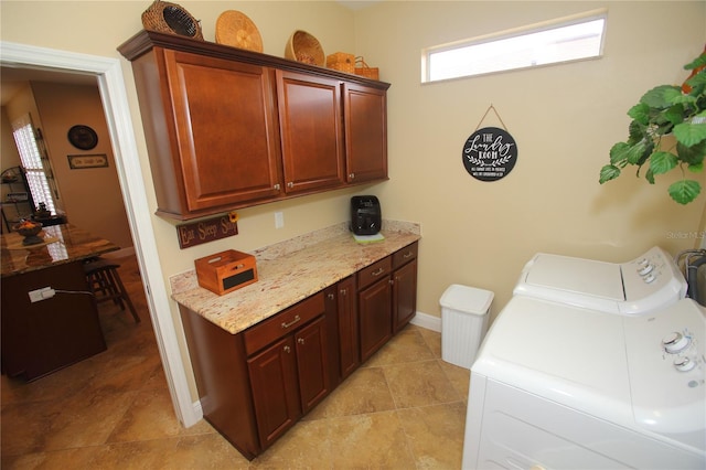 washroom with cabinets, independent washer and dryer, and light tile patterned floors