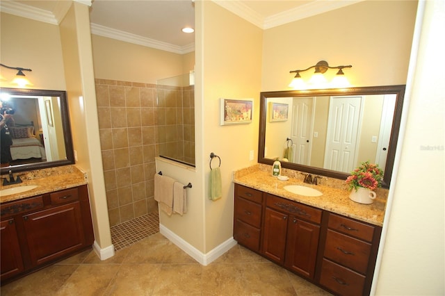 bathroom with ornamental molding, vanity, tiled shower, and tile patterned floors