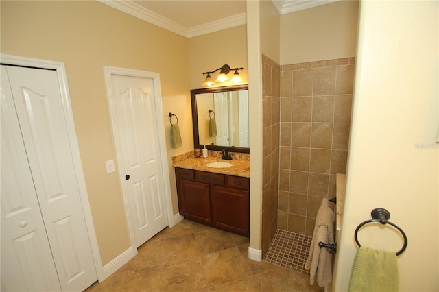 bathroom with ornamental molding, a tile shower, and vanity