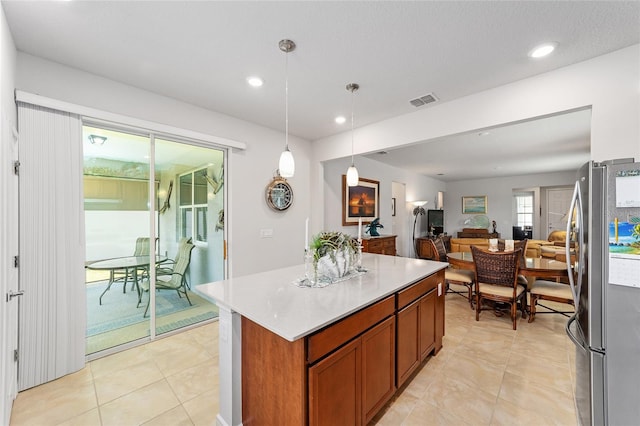 kitchen featuring pendant lighting, a center island, stainless steel refrigerator, and light tile patterned floors