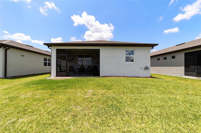 rear view of house with a sunroom and a yard