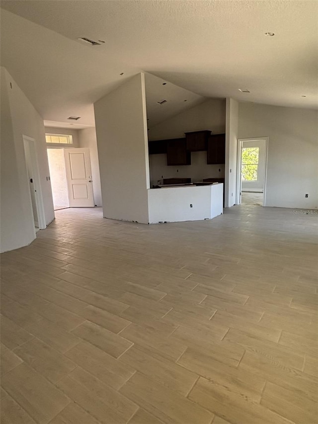 708 W Hallam Dr, Citrus Springs, FL 34434 - unfurnished living room with light wood finished floors and lofted ceiling