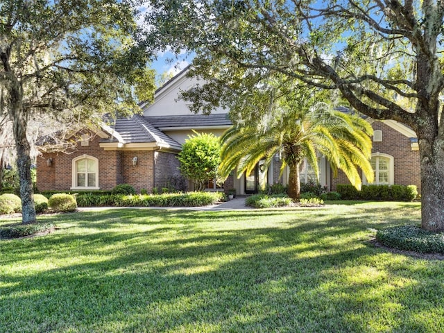 view of property hidden behind natural elements featuring a front yard