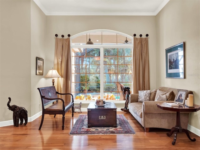 sitting room with crown molding and wood-type flooring