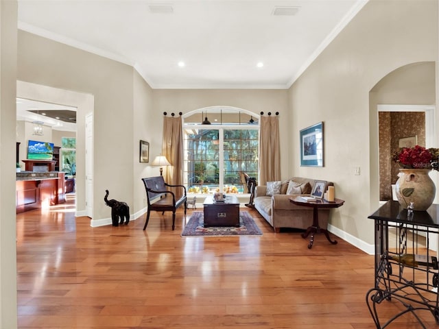 living room featuring wood-type flooring and crown molding