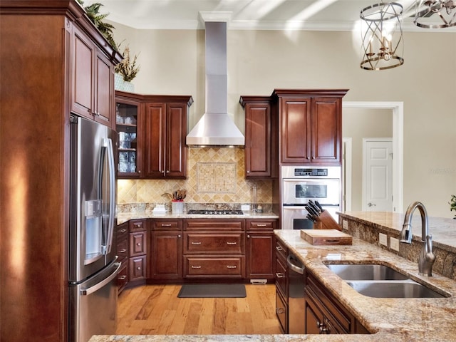 kitchen featuring wall chimney range hood, crown molding, sink, light hardwood / wood-style floors, and stainless steel appliances