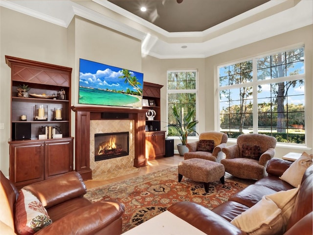 living room with ornamental molding and a tiled fireplace