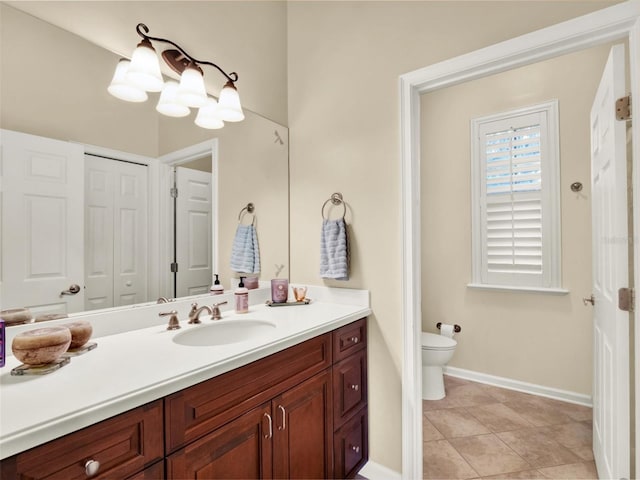 bathroom with toilet, vanity, and tile patterned floors