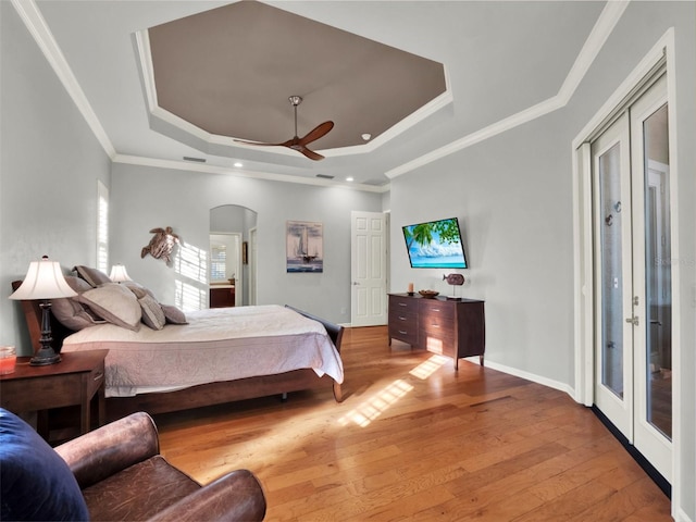 bedroom featuring french doors, light wood-type flooring, ceiling fan, and ornamental molding