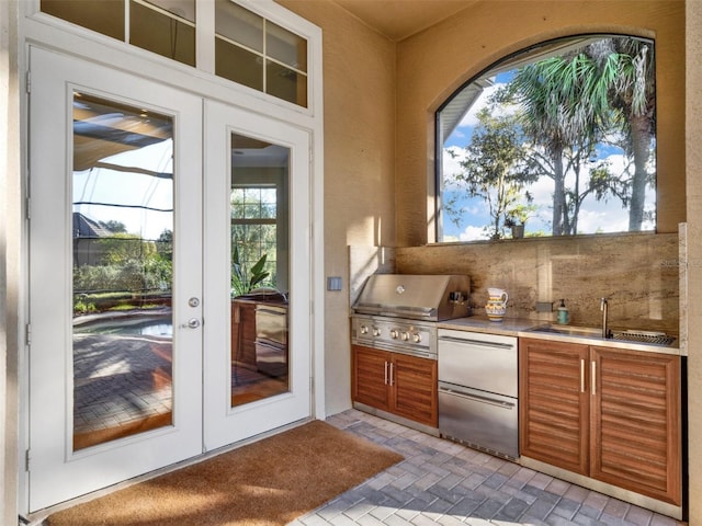 exterior space featuring a grill, exterior kitchen, sink, and french doors