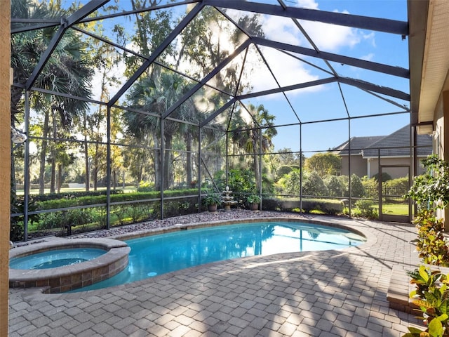 view of pool with glass enclosure, an in ground hot tub, and a patio