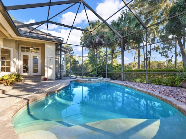 view of pool with glass enclosure, an in ground hot tub, french doors, and a patio area