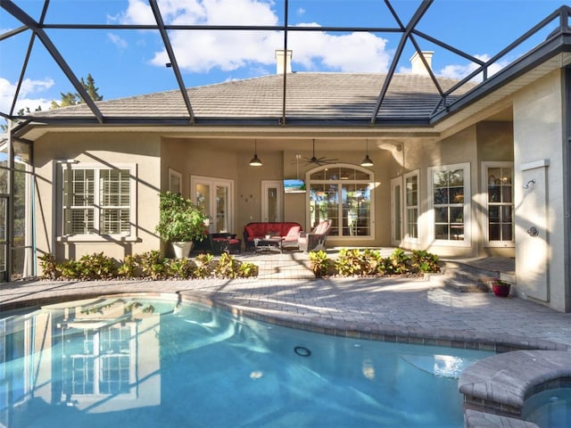 view of swimming pool featuring an outdoor hangout area, glass enclosure, ceiling fan, and a patio area