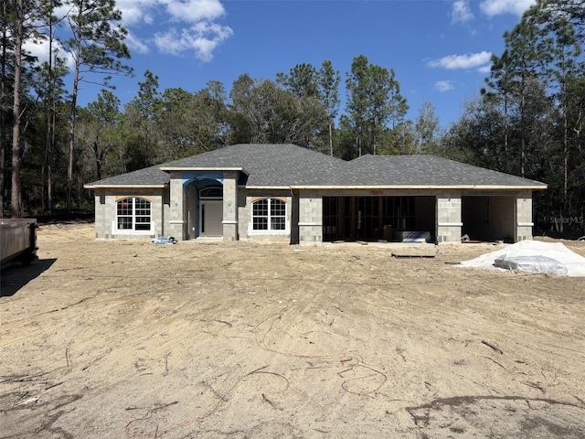 view of front of home with a garage, stone siding, and a shingled roof