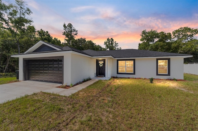 single story home with a lawn and a garage