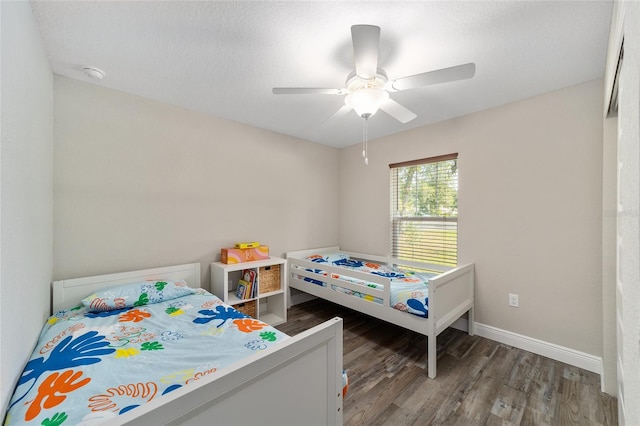 bedroom with ceiling fan, dark hardwood / wood-style floors, and a textured ceiling