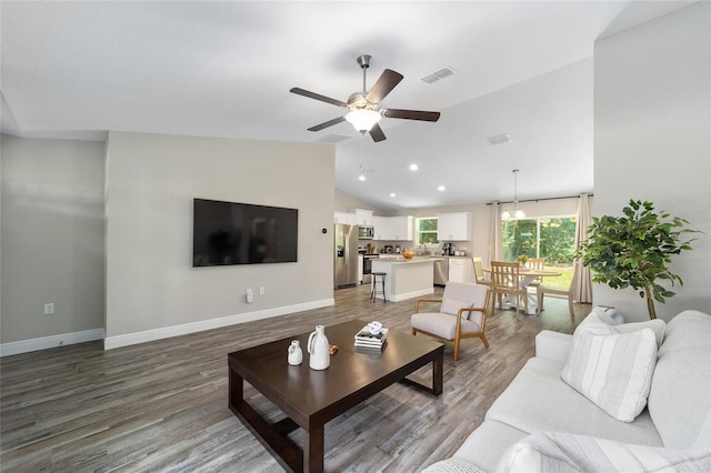 living room featuring ceiling fan with notable chandelier, wood-type flooring, and lofted ceiling