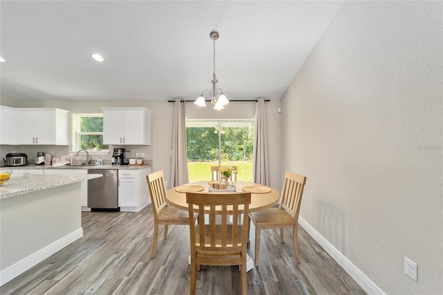 dining area featuring plenty of natural light, light hardwood / wood-style floors, and a chandelier